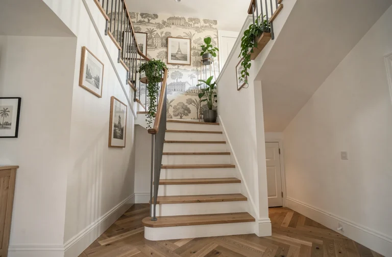 Cage d'escalier moderne et décorée avec garde-corps métallique, plantes retombantes, galerie photo et papier peint panoramique