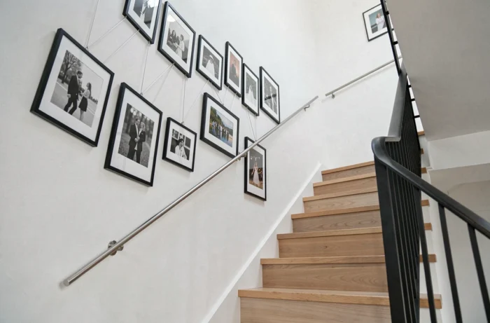 Galerie photo sur câbles métalliques accrochée le long des marches d'un escalier moderne
