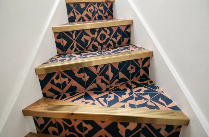 Marches d'escalier habillées de revêtement vinyle à motifs géométriques bleu marine et terracotta